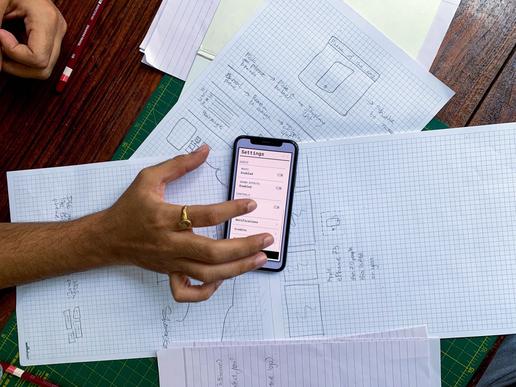 Usuario probando un prototipo móvil sobre bocetos en papel